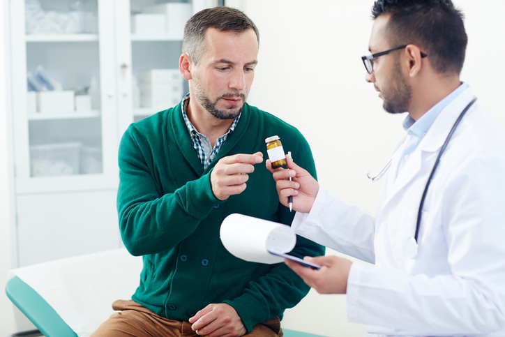 Doctor prescribing pills or vitamins to patient during medical consultation