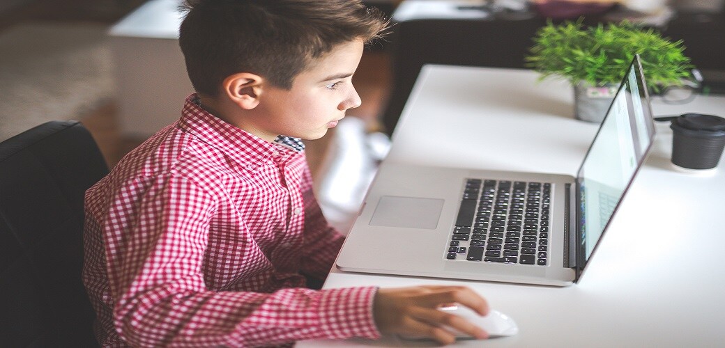 Shot of a young boy using a laptop at home